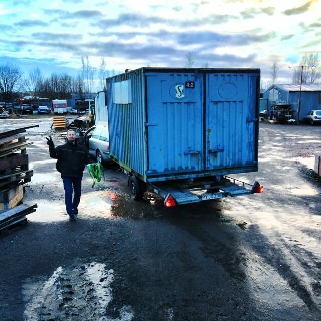 person som står framför bil med container på